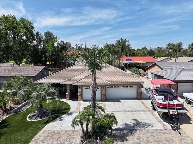23618 Canyon Lake Dr N, Canyon Lake, CA 92587 - single story home with driveway, an attached garage, stone siding, stucco siding, and a tiled roof