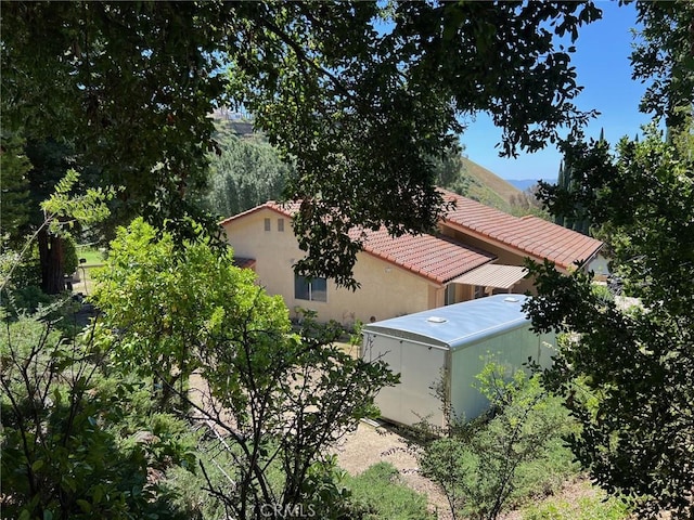 19628 Pine Valley Ave, Porter Ranch, CA 91326 - view of side of home featuring a tiled roof and stucco siding