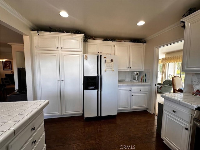 19628 Pine Valley Ave, Porter Ranch, CA 91326 - kitchen featuring white refrigerator with ice dispenser, tile counters, ornamental molding, white cabinetry, and backsplash