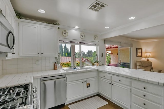 19628 Pine Valley Ave, Porter Ranch, CA 91326 - kitchen featuring stainless steel appliances, a sink, crown molding, decorative backsplash, and white cabinetry