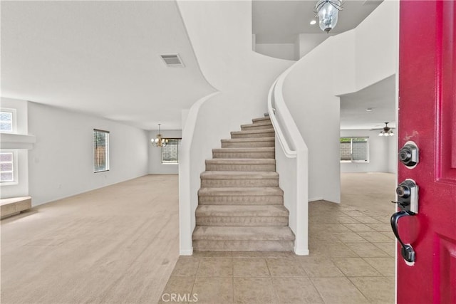 5564 Capri Ct, Palmdale, CA 93552 - foyer with light colored carpet, stairs, light tile patterned flooring, and a chandelier