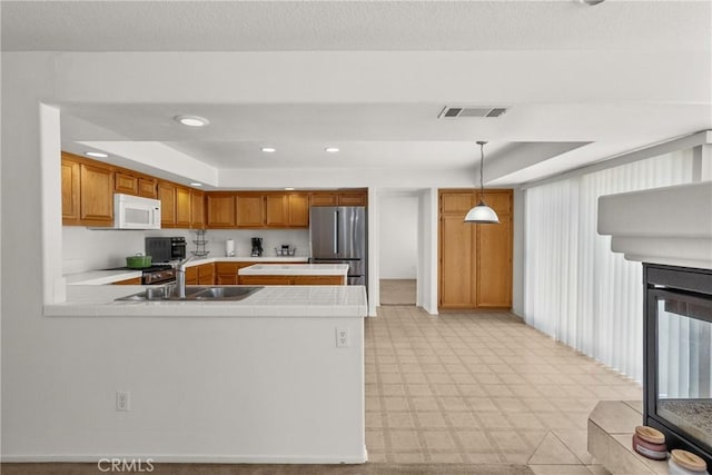 5564 Capri Ct, Palmdale, CA 93552 - kitchen featuring tile counters, appliances with stainless steel finishes, a raised ceiling, a peninsula, and a sink