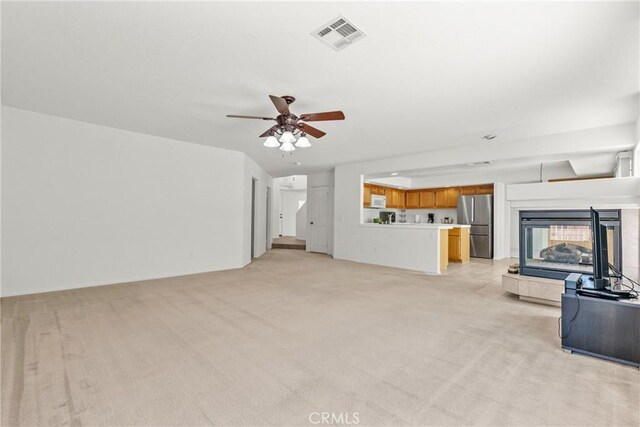 5564 Capri Ct, Palmdale, CA 93552 - unfurnished living room featuring light carpet, a ceiling fan, and a multi sided fireplace