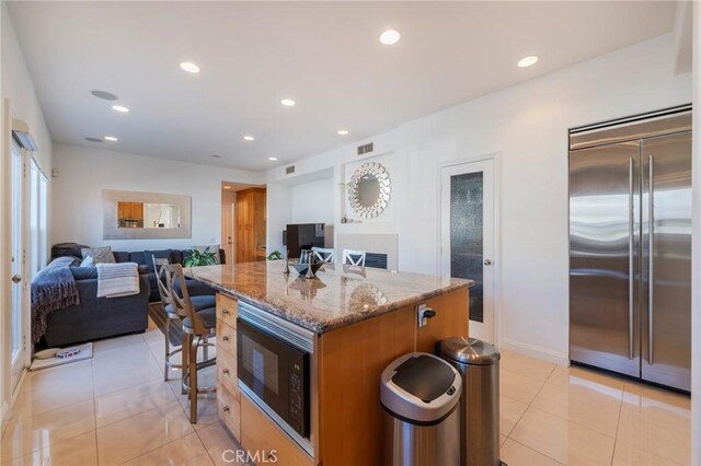 428 12th St, Huntington Beach, CA 92648 - kitchen featuring built in appliances, stone countertops, open floor plan, a center island, and light tile patterned floors