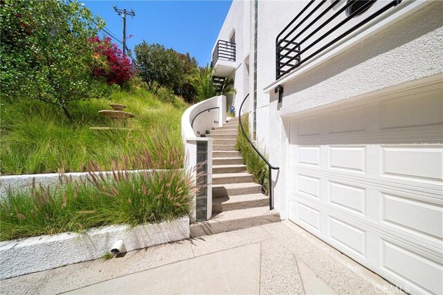 9314 Stevens Way, West Hills, CA 91304 - view of side of home with a garage, stairs, and stucco siding