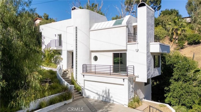 9314 Stevens Way, West Hills, CA 91304 - art deco house featuring a balcony, stucco siding, a chimney, stairs, and concrete driveway