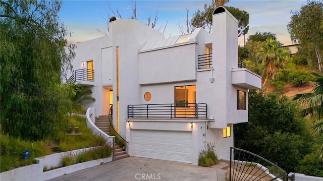 9314 Stevens Way, West Hills, CA 91304 - art deco inspired home featuring a balcony, stairs, concrete driveway, a garage, and stucco siding