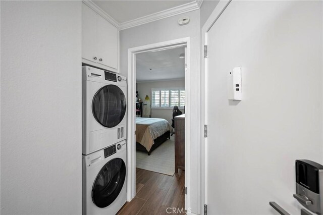615 Esplanade Unit 509, Redondo Beach, CA 90277 - laundry room featuring stacked washer / drying machine, dark wood-style flooring, and ornamental molding