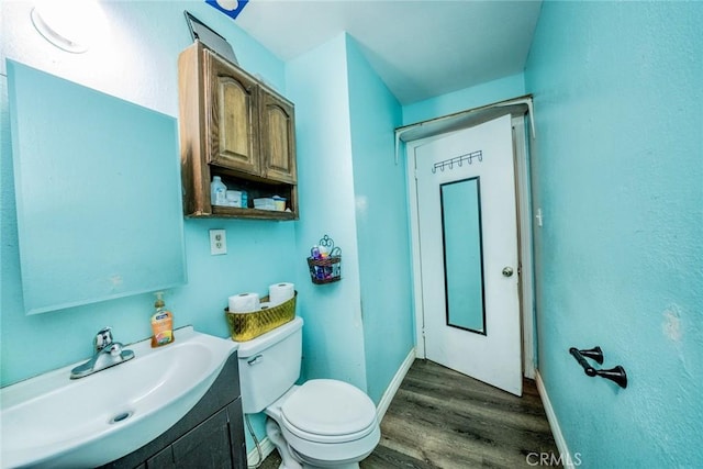 1544 S Pleasant Ave, Ontario, CA 91761 - half bathroom featuring wood finished floors, baseboards, toilet, and vanity