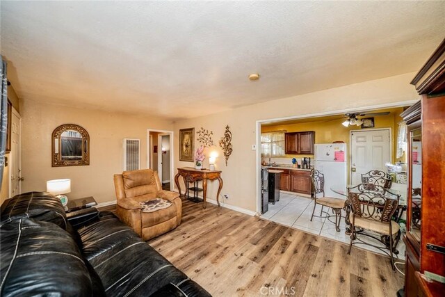 1544 S Pleasant Ave, Ontario, CA 91761 - living area featuring light wood-type flooring, ceiling fan, and baseboards