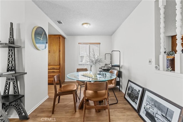 2210 El Rancho Cir, Hemet, CA 92545 - dining area with light wood-style floors, a textured ceiling, and baseboards