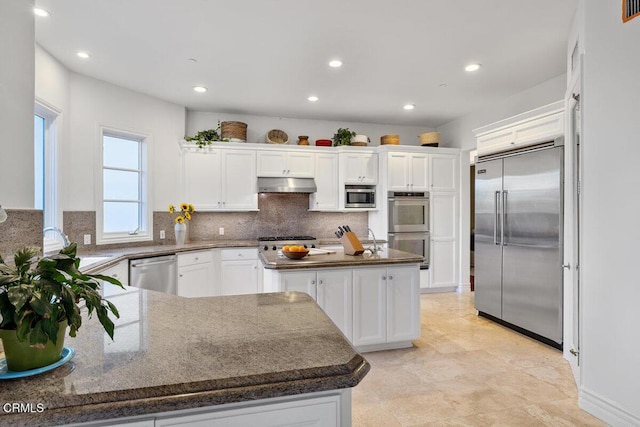 12986 Macdonald Dr, Ojai, CA 93023 - kitchen featuring built in appliances, under cabinet range hood, white cabinets, recessed lighting, and decorative backsplash