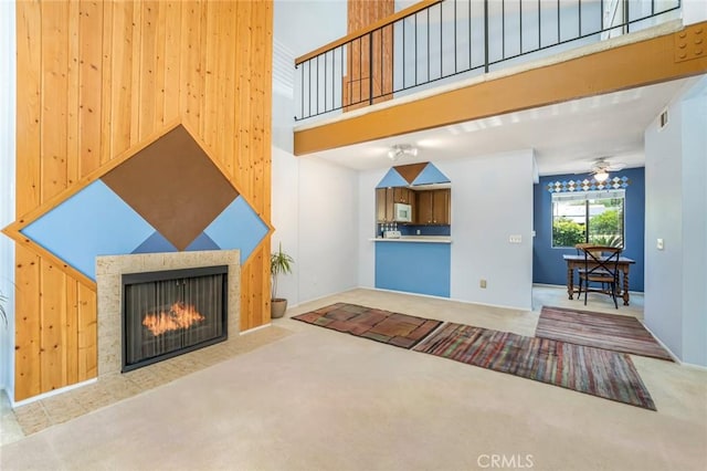 917 W Imperial Unit 64, La Habra, CA 90631 - unfurnished living room with carpet flooring, a fireplace with flush hearth, a high ceiling, and ceiling fan