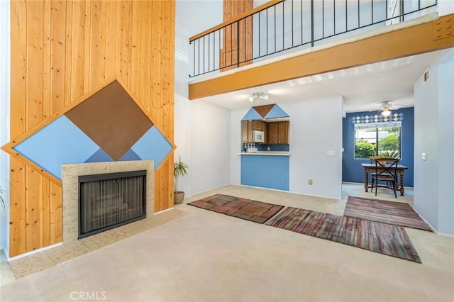 917 W Imperial Unit 64, La Habra, CA 90631 - unfurnished living room with a fireplace with flush hearth, carpet, ceiling fan, and a towering ceiling