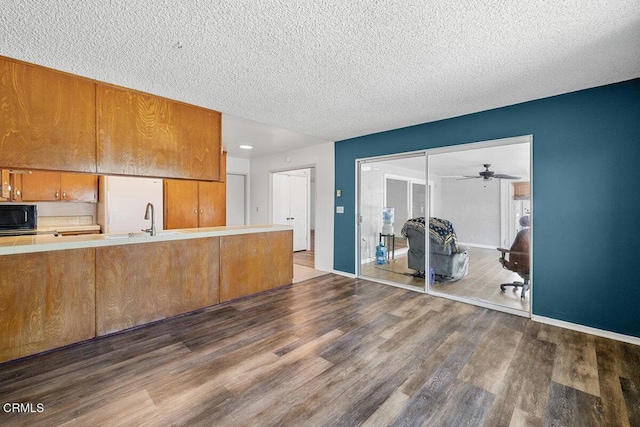 203 E Garden Grn, Port Hueneme, CA 93041 - kitchen with black microwave, brown cabinets, tile countertops, a textured ceiling, and wood finished floors
