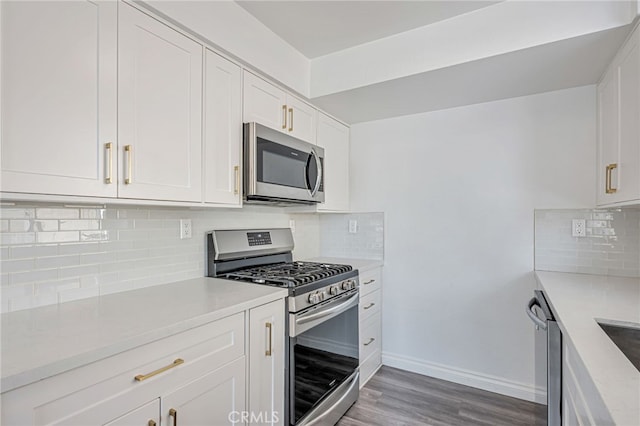 10290 Tujunga Canyon Blvd Unit 102, Tujunga, CA 91402 - kitchen featuring appliances with stainless steel finishes, decorative backsplash, white cabinets, light wood finished floors, and baseboards