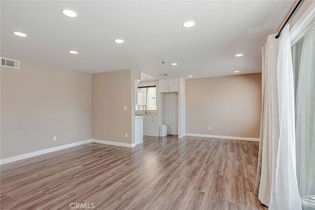 10290 Tujunga Canyon Blvd Unit 102, Tujunga, CA 91402 - unfurnished living room with light wood-style floors, baseboards, a sink, and recessed lighting