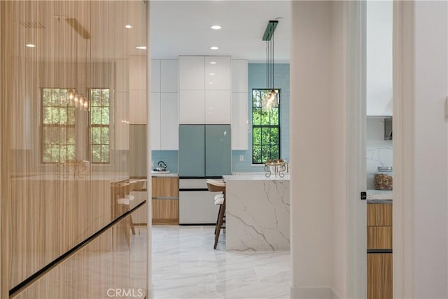 bathroom with marble tiled floors, tasteful backsplash, and recessed lighting