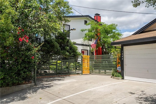 exterior space with fence, a gate, and a chimney