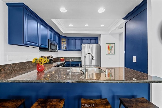 3936 W 5th St Unit 44, Santa Ana, CA 92703 - kitchen with stainless steel appliances, a sink, blue cabinetry, a peninsula, and dark stone countertops