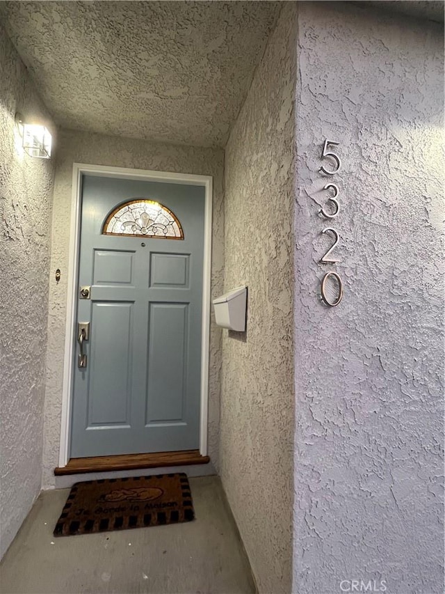 view of exterior entry featuring stucco siding