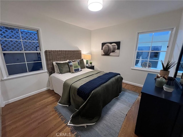 bedroom with wood finished floors and baseboards