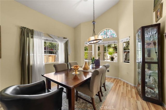 23838 Spring Branch Ct, Murrieta, CA 92562 - dining area with light wood-style flooring, baseboards, and high vaulted ceiling