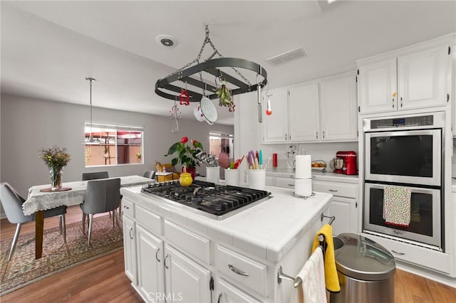 23838 Spring Branch Ct, Murrieta, CA 92562 - kitchen featuring stainless steel appliances, tile countertops, light wood-type flooring, and white cabinetry