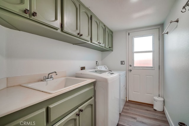 10025 Thornbird Ct, Moreno Valley, CA 92557 - washroom featuring cabinet space, washing machine and dryer, light wood-style floors, and baseboards