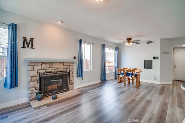 10025 Thornbird Ct, Moreno Valley, CA 92557 - living area featuring wood finished floors, a fireplace, a ceiling fan, and baseboards