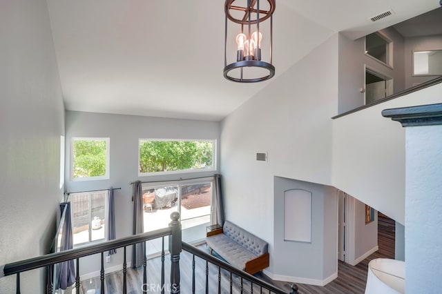 10025 Thornbird Ct, Moreno Valley, CA 92557 - staircase featuring high vaulted ceiling, wood finished floors, a chandelier, and baseboards