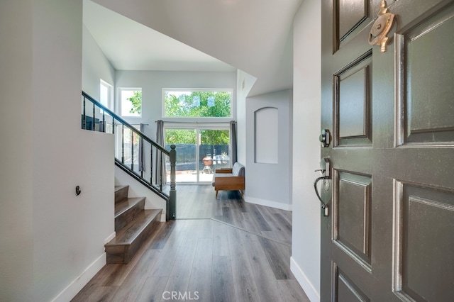 10025 Thornbird Ct, Moreno Valley, CA 92557 - foyer entrance with baseboards, wood finished floors, and stairway