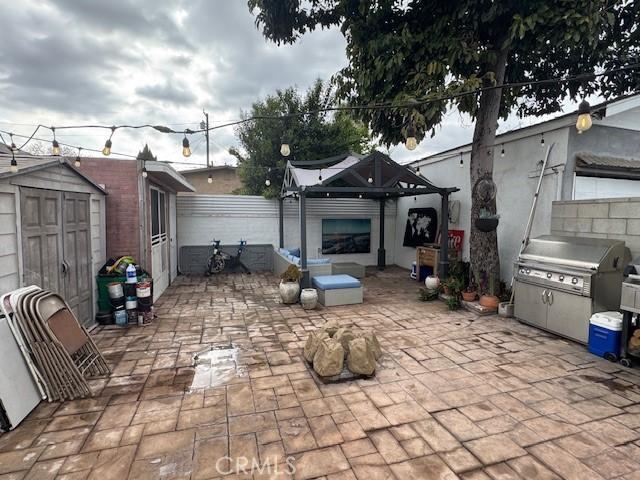 807 N Pearl Ave, Compton, CA 90221 - view of patio with a storage shed, an outdoor structure, area for grilling, and fence