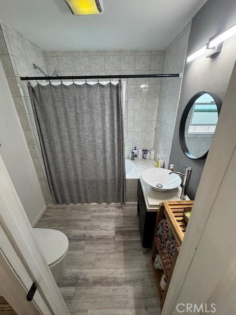 807 N Pearl Ave, Compton, CA 90221 - bathroom featuring wood finished floors, toilet, vanity, and tiled shower / bath