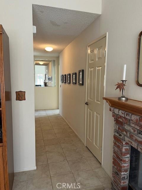 3060 Summer Set Cir, Banning, CA 92220 - corridor featuring light tile patterned floors and a textured ceiling