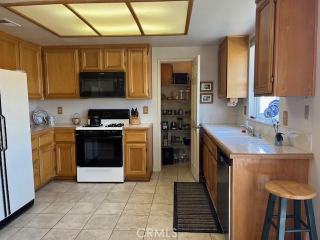 3060 Summer Set Cir, Banning, CA 92220 - kitchen with white appliances, a sink, and light tile patterned floors