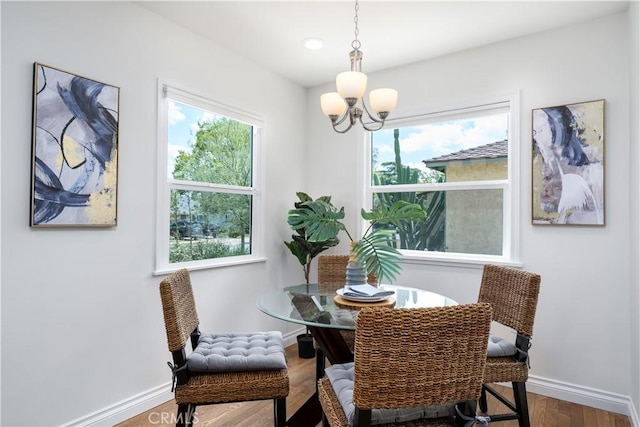 dining room with a chandelier, baseboards, and wood finished floors