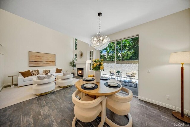 13385 Savanna, Tustin, CA 92782 - dining space featuring dark wood finished floors, a chandelier, baseboards, and a glass covered fireplace