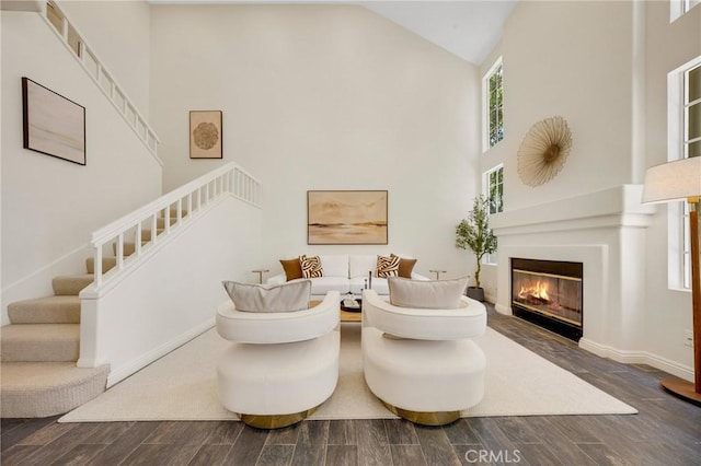 13385 Savanna, Tustin, CA 92782 - living area featuring high vaulted ceiling, stairs, wood finished floors, a glass covered fireplace, and baseboards