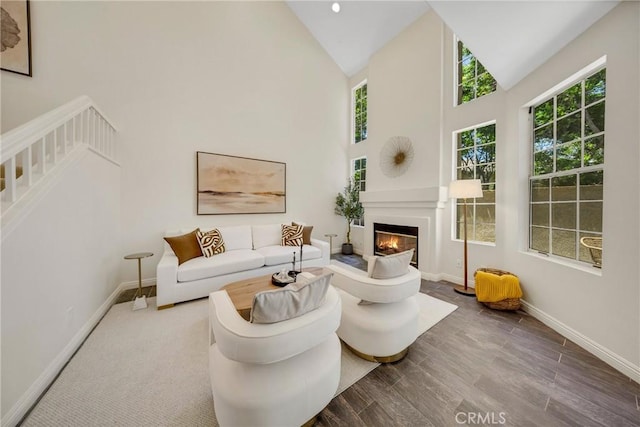 13385 Savanna, Tustin, CA 92782 - living room with high vaulted ceiling, a glass covered fireplace, wood finished floors, and baseboards