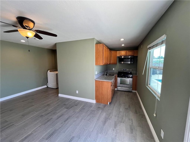 136 S Fircroft St, West Covina, CA 91791 - kitchen with appliances with stainless steel finishes, a sink, brown cabinets, washer / dryer, and wood finished floors