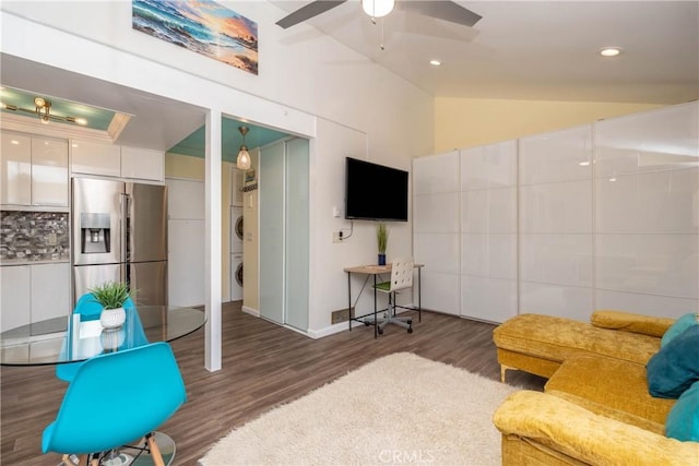 17072 Pacific Coast Unit 202, Huntington Beach, CA 92649 - living room with stacked washer / drying machine, wood finished floors, vaulted ceiling, a ceiling fan, and baseboards