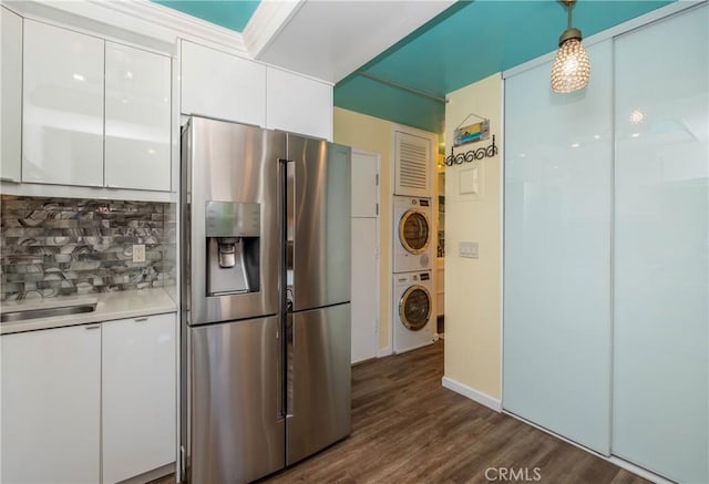 17072 Pacific Coast Unit 202, Huntington Beach, CA 92649 - kitchen with stacked washer / drying machine, stainless steel refrigerator with ice dispenser, white cabinetry, tasteful backsplash, and dark wood-type flooring