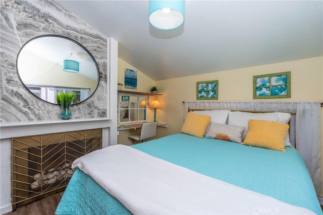 17072 Pacific Coast Unit 202, Huntington Beach, CA 92649 - bedroom featuring vaulted ceiling, wood finished floors, and a fireplace