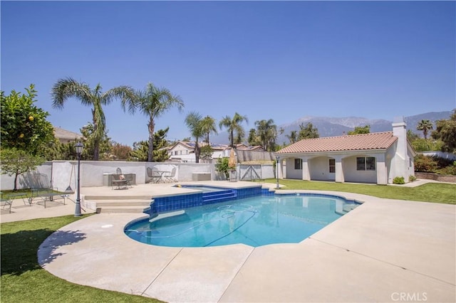 view of pool with a patio area, a mountain view, and a pool with connected hot tub