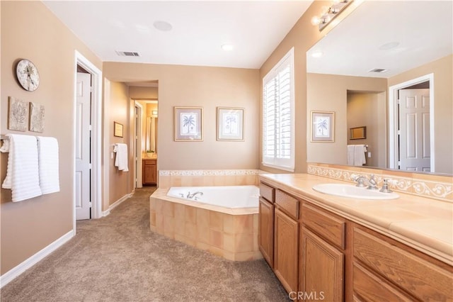 bathroom with a garden tub, vanity, baseboards, and carpet floors