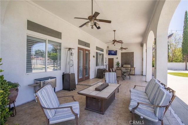 view of patio / terrace with a ceiling fan, outdoor dining space, french doors, and an outdoor living space with a fire pit
