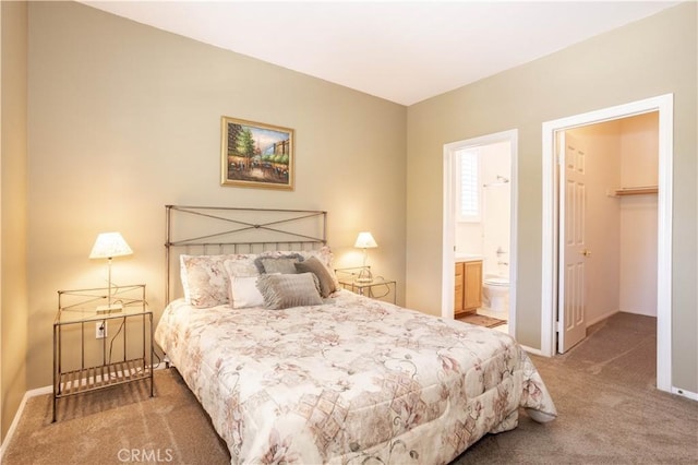 bedroom with carpet flooring, baseboards, a spacious closet, and connected bathroom