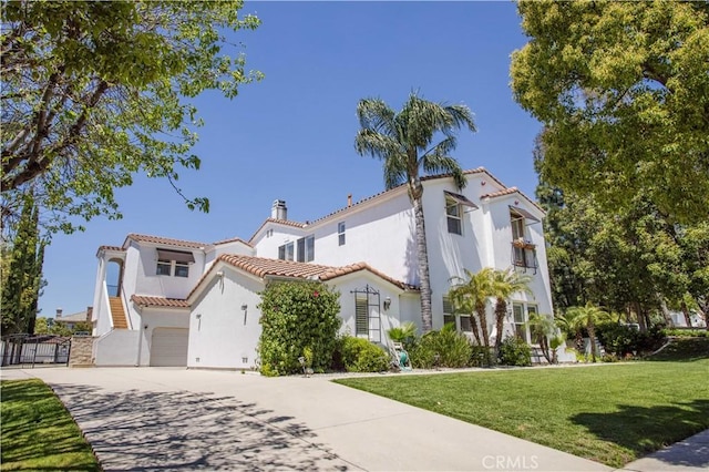 mediterranean / spanish-style home featuring a tiled roof, driveway, stucco siding, a front yard, and a chimney