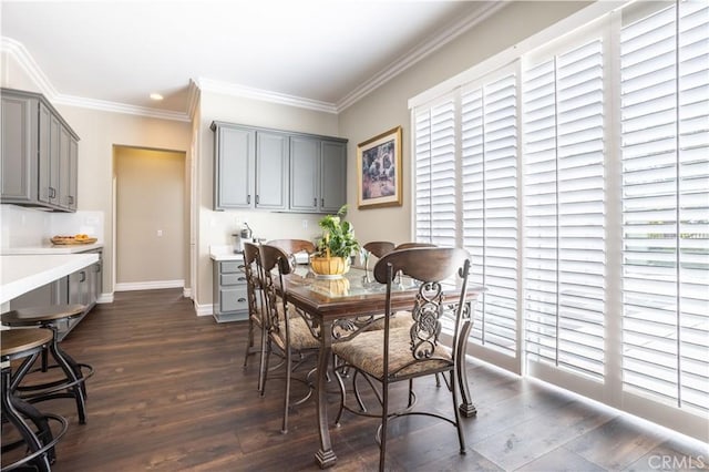 dining space with dark wood-type flooring, healthy amount of natural light, crown molding, and baseboards